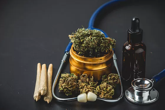 Stethoscope, cannabis flowers, marijuana extract oil and paper rolled joint