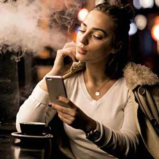 Young woman vaping with thick smoke