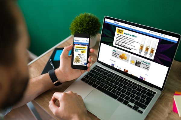Man with laptop and mobile, with both devices displaying the My 7 Engines home page