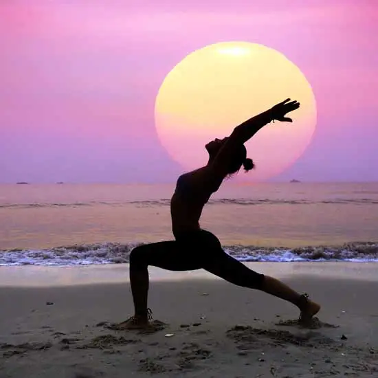 Silhouette of a woman doing yoga at dusk.