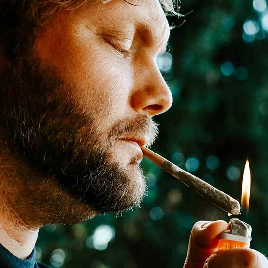 Bearded man lighting up a joint