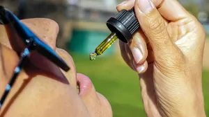 Woman consuming CBD from a dropper.