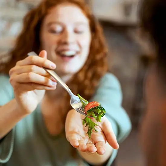 Friendship Day Special ideas from 7Engines - woman holding up a fork with delicious looking food. Cooking night!