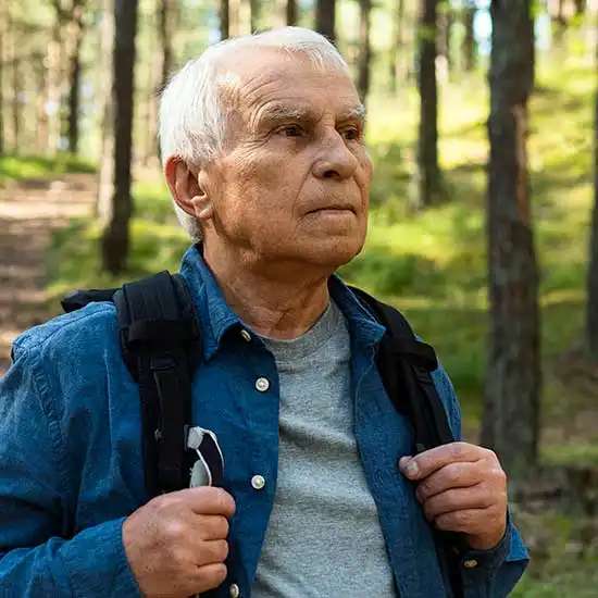 Elderly man taking a walk in the woods