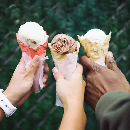 3 hands holding ice cream cones