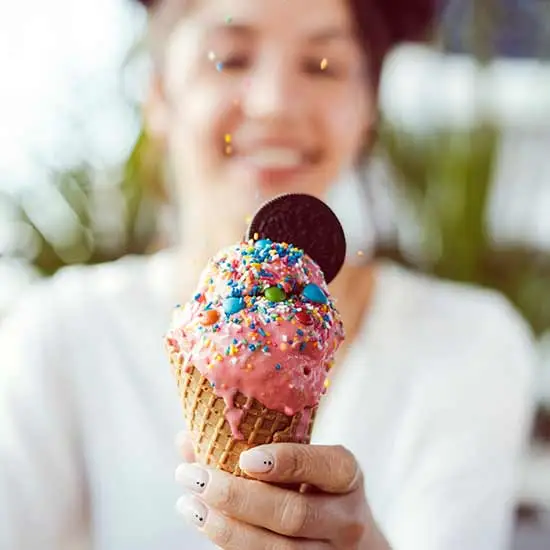 Girl holding up an ice cream cone on national ice cream day