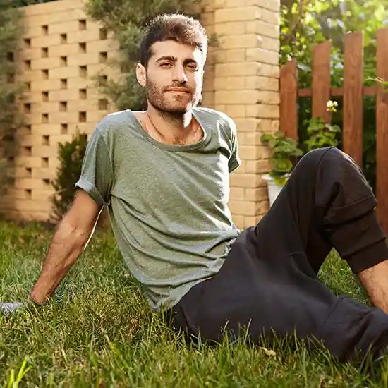 Young man sitting and relaxing in his backyard