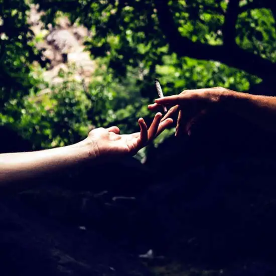 Two hands reaching for each other on World Kindness Day. One has a joint