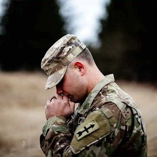 Soldier in uniform in prayer