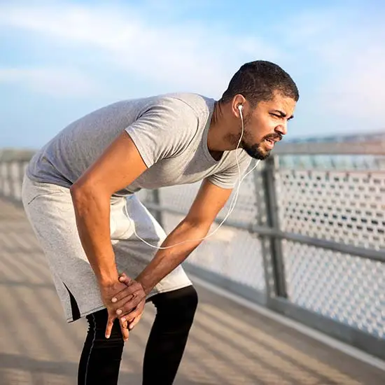 Man holding right knee out of pain from muscle disabilities